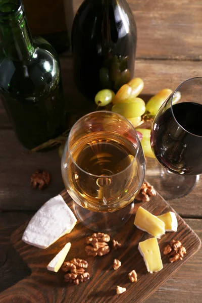 Schönes Stillleben mit Wein, Käse und reifen Trauben auf Holzgrund — Stockfoto