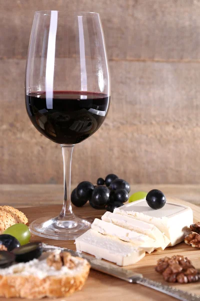 Hermoso bodegón con vino, queso y uva madura sobre fondo de madera — Foto de Stock
