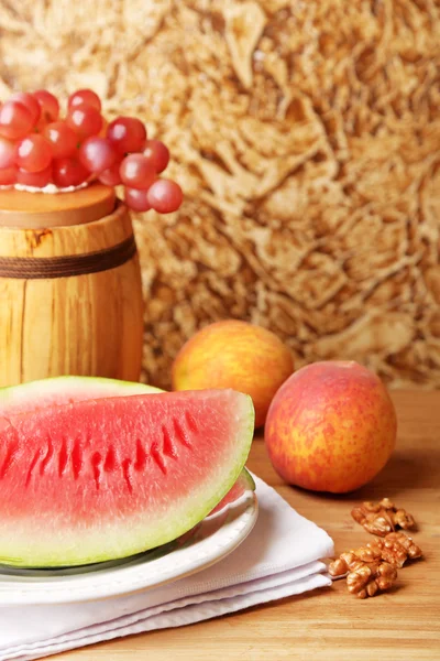 Composição de melancia madura, frutas e barril de madeira na tabela de madeira da cor, no fundo da parede da cor — Fotografia de Stock
