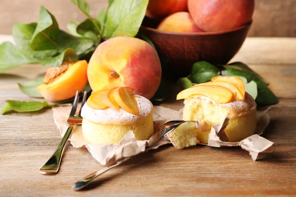 Leckere Mini-Kuchen mit frischem Pfirsich, auf Holztisch — Stockfoto