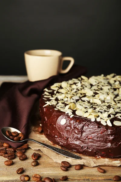 Leckere Schokoladenkuchen mit Mandeln, auf Holztisch, auf dunklem Hintergrund — Stockfoto