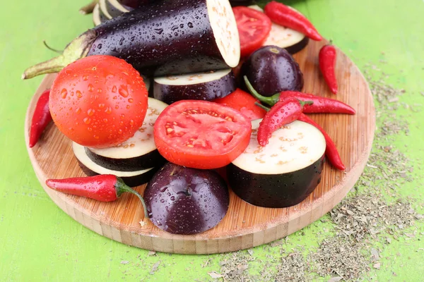 Hackad auberginer med tomater och kyligt peppar på skärbräda på trä bakgrund — Stockfoto