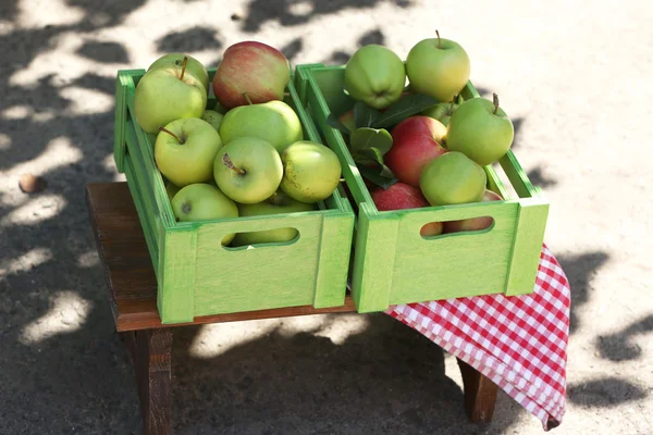 Juicy apples in wooden box, outdoors — Stock Photo, Image