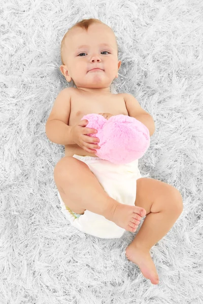 Schattige babyjongen liggend op tapijt in kamer — Stockfoto