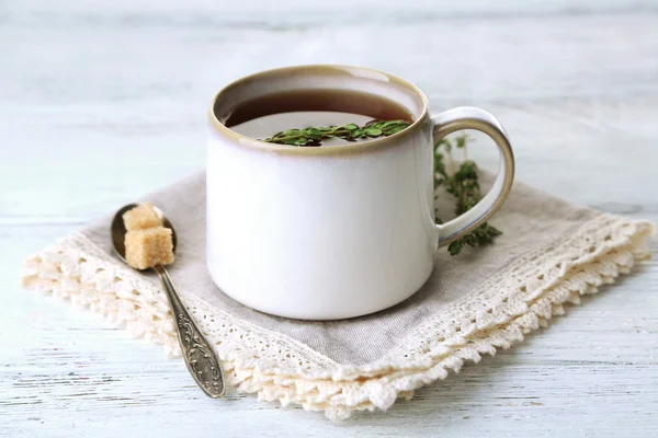 Cup of tasty herbal tea with thyme on wooden table — Stock Photo, Image