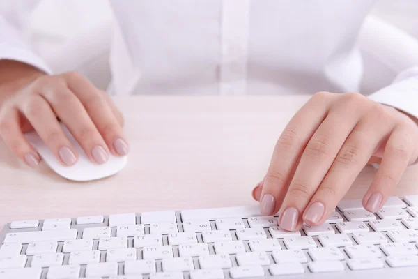 Mani femminili digitando sulla tastiera su sfondo chiaro — Foto Stock