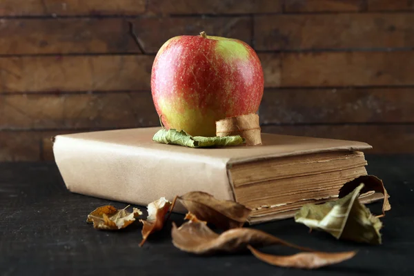 Apple med bok och torra löv — Stockfoto