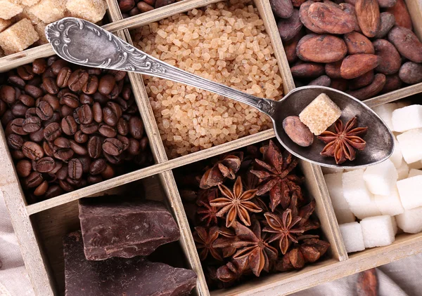 Kotak kayu dengan satu set kopi dan biji kakao, gula batu, cokelat gelap, kayu manis dan adas, close-up — Stok Foto