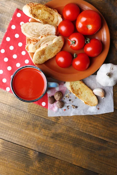 Sumo de tomate caseiro na caneca a cores, torradas e tomates frescos no fundo de madeira — Fotografia de Stock