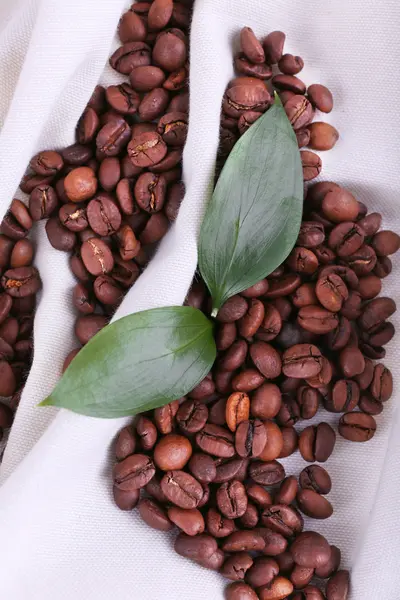Coffee beans on white napkin on wooden background closeup — Stock Photo, Image