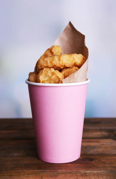 Nuggets de frango na xícara com molhos na mesa em fundo brilhante — Fotografia de Stock