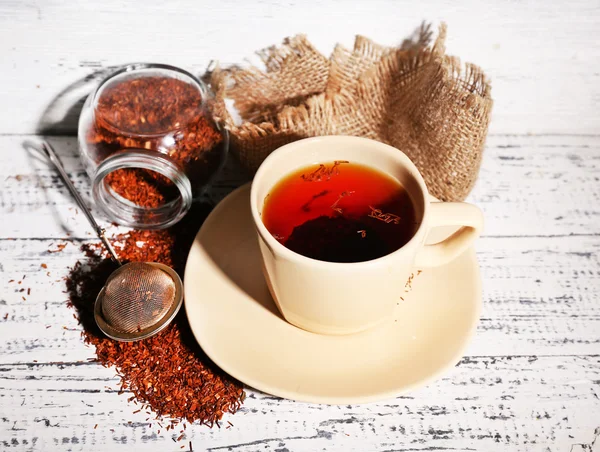 Cup of tasty rooibos tea, on old white wooden table — Stock Photo, Image