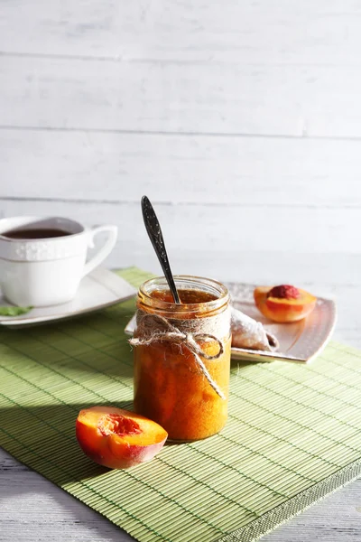 Leichtes Frühstück mit Tasse Tee und hausgemachter Marmelade auf Holztisch — Stockfoto