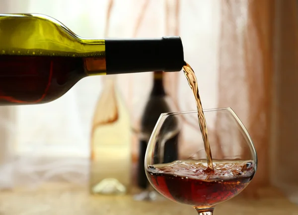 Red wine pouring into wine glass, close-up — Stock Photo, Image