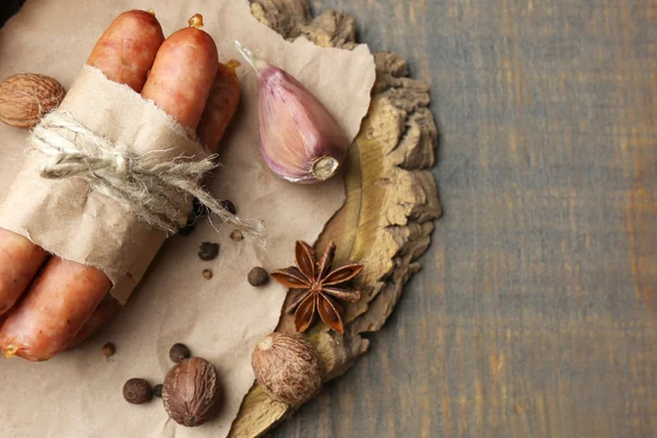 薄的香肠，芥末碗和木制背景上的香料的组成 — 图库照片