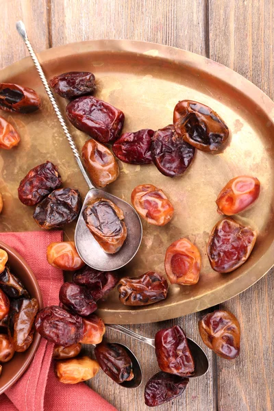 Tasty dates fruits on old metal tray, on wooden background — Stock Photo, Image