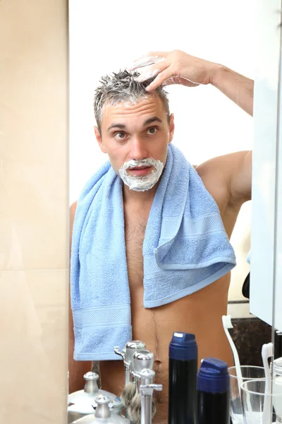 Jovem barbear sua barba no banheiro — Fotografia de Stock