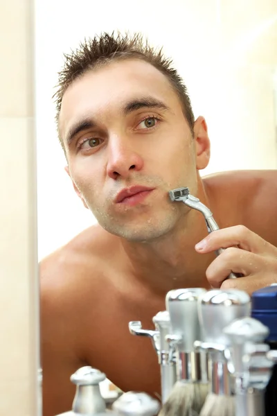 Joven afeitándose la barba en el baño — Foto de Stock