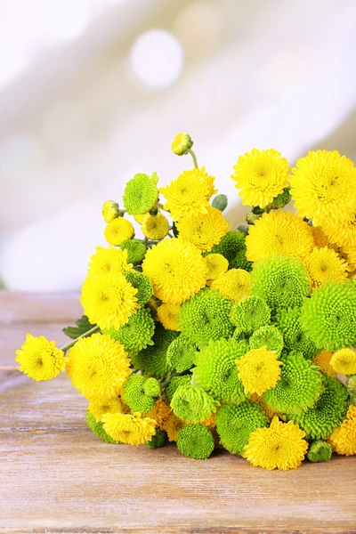 Bellissimo bouquet di fiori di crisantemi su tavolo di legno, su sfondo chiaro — Foto Stock