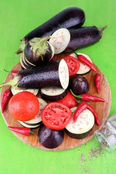 Ahşap zemin üzerinde kesme tahtası üzerinde serin biber ve domates ile doğranmış patlıcan — Stok fotoğraf
