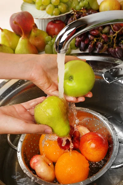 여자의 손을 싱크대에 소 쿠리에 사과 다른 과일을 세척 — 스톡 사진