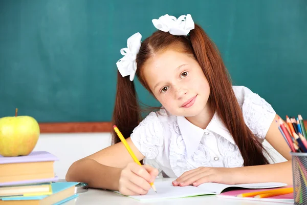 Menina bonito no local de trabalho em sala de aula — Fotografia de Stock