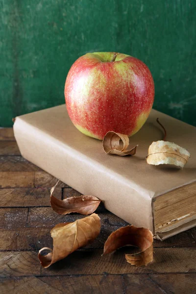 Manzana con libros y hojas secas — Foto de Stock
