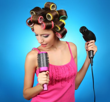 mavi zemin üzerine saç curlers içinde güzel bir kız