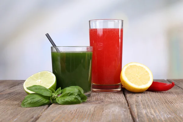 Bicchieri di succo di verdura con lime e limone sul tavolo di legno — Foto Stock