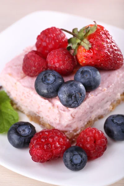 Pastel con frutas y bayas en plato sobre fondo de madera —  Fotos de Stock