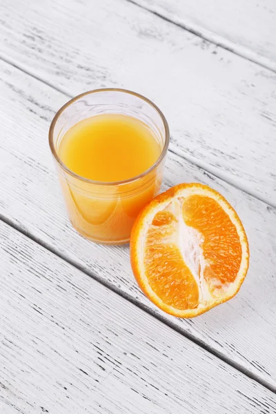 Glas juice och läckra orange på träbord — Stockfoto
