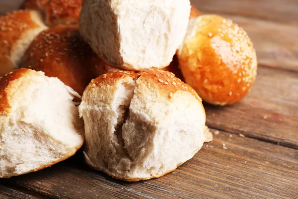 Lekkere broodjes met sesame op een houten achtergrond kleur — Stockfoto