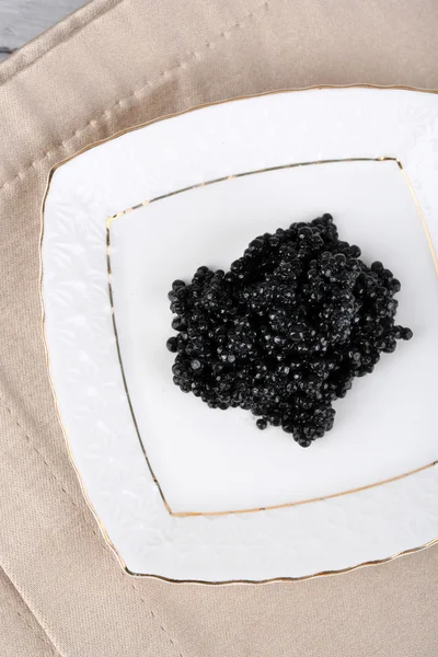 Caviale nero sul piatto sul primo piano del tovagliolo — Foto Stock