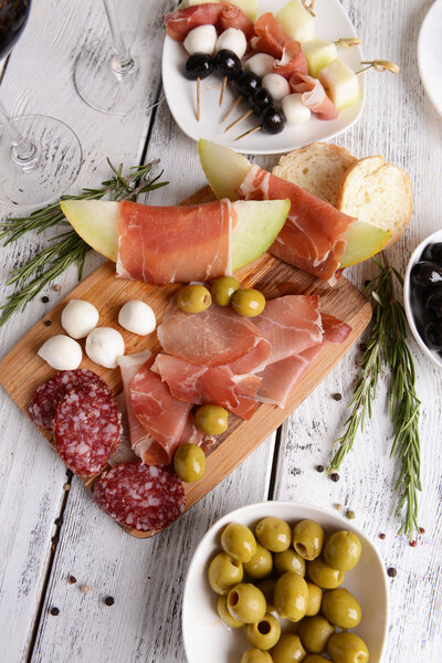 Delicious melon with prosciutto on table close-up