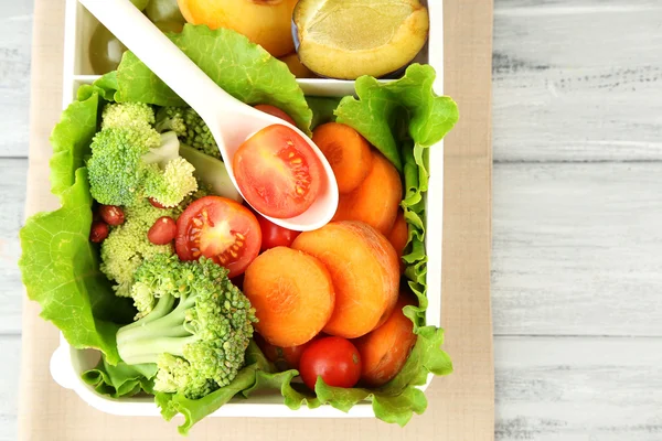 Sabrosa comida vegetariana en caja de plástico sobre mesa de madera —  Fotos de Stock