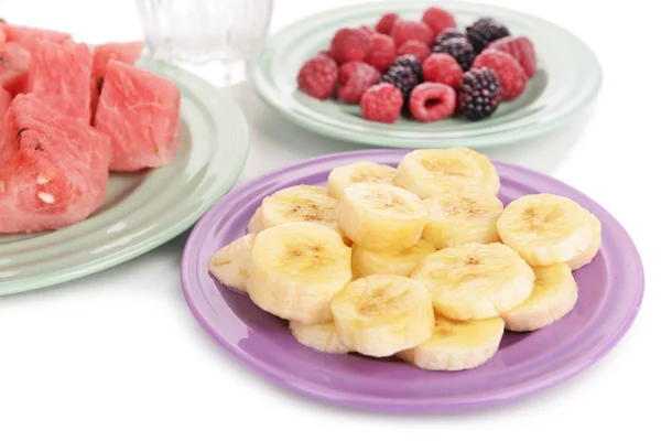 Frutas fatiadas e bagas no prato com vidro de água de perto — Fotografia de Stock