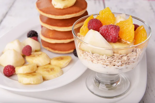 Panqueque con frutas y muesli en el plato en la mesa de cerca — Foto de Stock