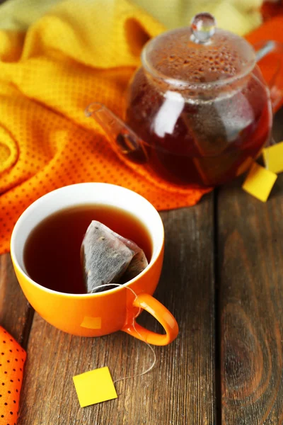Cup of tea, teapot and tea bags on wooden table close-up — Stock Photo, Image