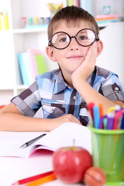 Skolpojke sitter vid bord i klassrummet — Stockfoto