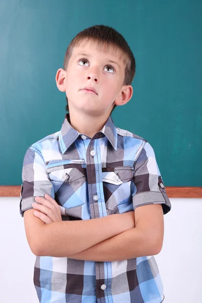Schoolboy at blackboard in classroom — Stock Photo, Image