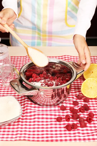 Frau kocht Himbeermarmelade in Küche — Stockfoto