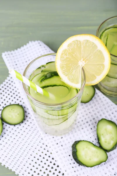 Glass of cucumber cocktail on napkin on wooden background — Stock Photo, Image