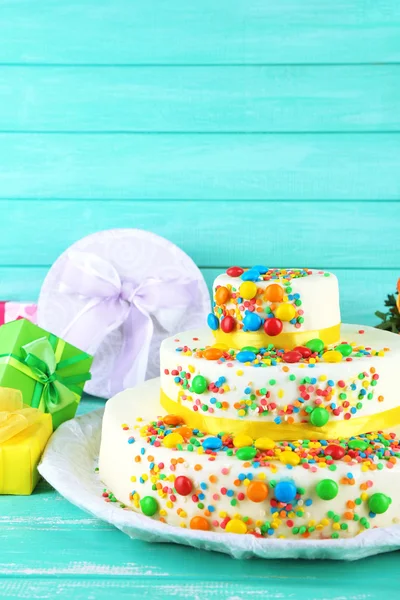 Hermoso pastel de cumpleaños sabroso y regalos en color fondo de madera —  Fotos de Stock