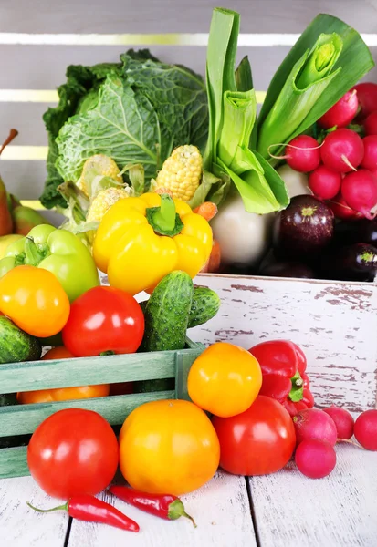 Légumes dans des boîtes en bois sur fond de boîte en bois blanc — Photo