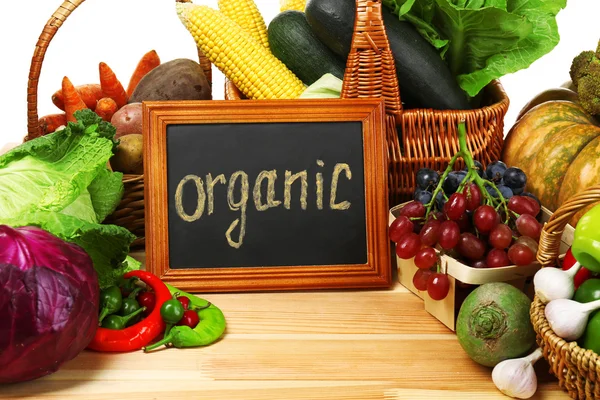 Sayuran organik segar dengan papan tulis di atas meja kayu, tutup — Stok Foto
