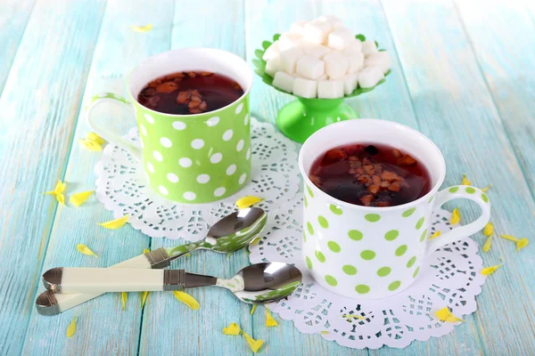 Dos tazas de té y azúcar con lunares sobre fondo de madera — Foto de Stock