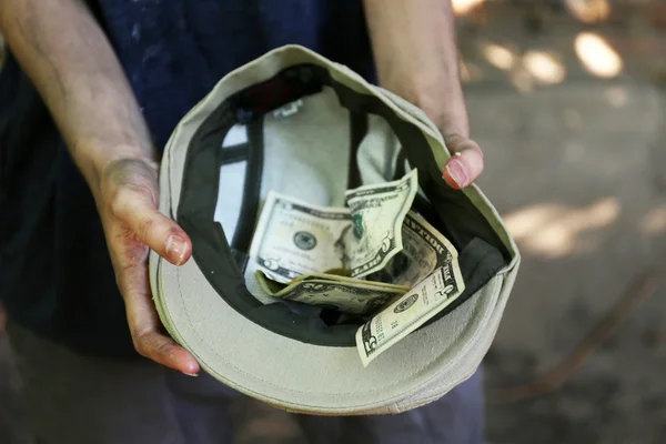 Homeless beggar money on his hat — Stock Photo, Image