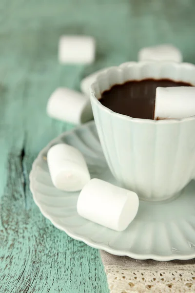 Chocolate quente com marshmallows na caneca, no fundo de madeira — Fotografia de Stock