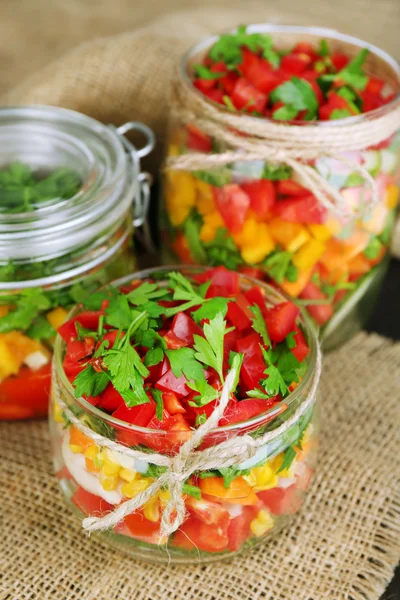 Ensalada de verduras en frascos de vidrio, sobre fondo de madera — Foto de Stock