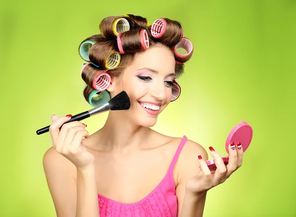 Menina bonita em encrespadores de cabelo no fundo verde — Fotografia de Stock